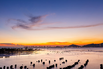 Image showing Sunset over sandy beach in low tide 