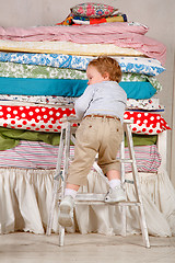 Image showing Child climbs on the bed - Princess and the Pea.