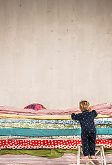 Image showing Child climbs on the bed - Princess and the Pea.