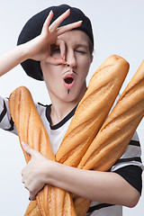 Image showing woman holding baguettes isolated with ok sign on white