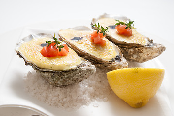 Image showing oysters with sauce and lemon on plate