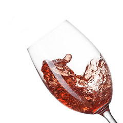 Image showing Red wine pouring into glass with splash isolated on white