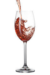 Image showing Red wine pouring into glass with splash isolated on white