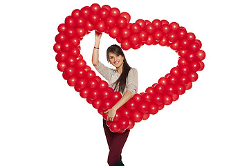 Image showing Smiling woman holding red balloon heart