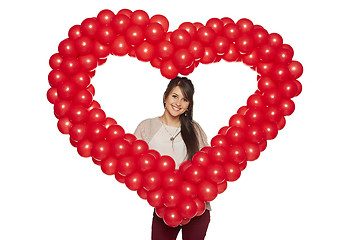 Image showing Smiling woman holding red balloon heart