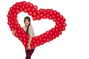 Image showing Smiling woman holding red balloon heart