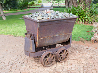 Image showing Rusted old mining carriages filled with stones