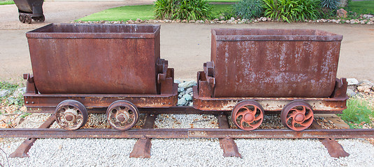 Image showing Rusted old mining carriages filled with stones