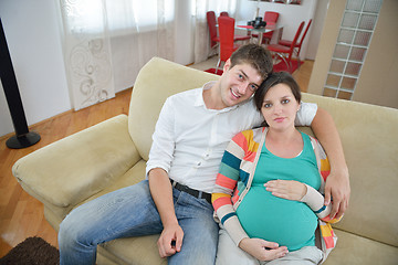 Image showing pregnant couple at home using tablet computer