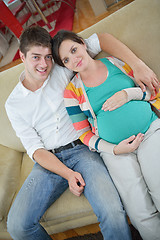 Image showing pregnant couple at home using tablet computer