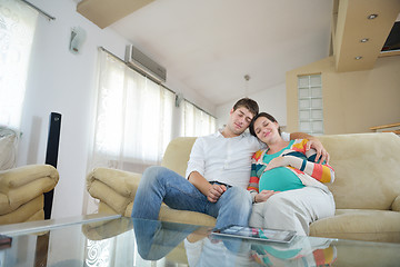 Image showing pregnant couple at home using tablet computer