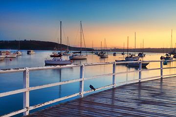 Image showing Boats moored bobbing in the waters at sunrise