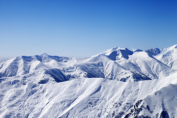 Image showing Snowy winter mountains and blue sky, view from ski slope