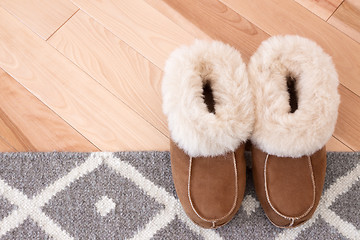 Image showing Rug and slippers on wooden floor