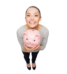 Image showing happy woman with piggy bank