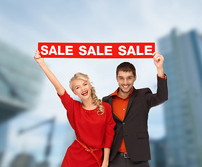 Image showing smiling woman and man with red sale sign