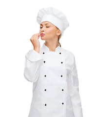 Image showing smiling female chef showing delicious sign