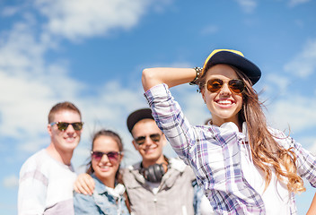 Image showing teenage girl with headphones and friends outside