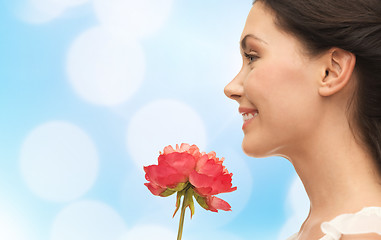 Image showing smiling woman smelling flower