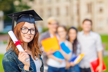 Image showing smiling teenage girl in corner-cap with diploma