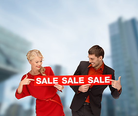 Image showing smiling woman and man with red sale sign