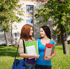 Image showing two smiling students with bag and folders