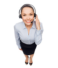 Image showing friendly female helpline operator with headphones