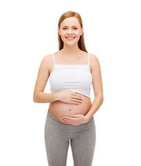 Image showing happy future mother touching her belly