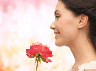 Image showing smiling woman smelling flower