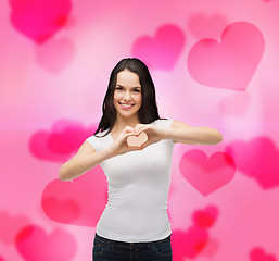 Image showing smiling girl showing heart with hands