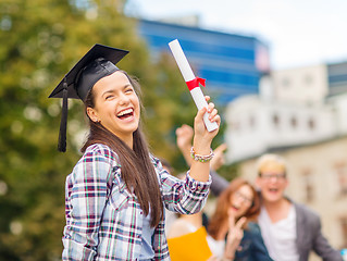 Image showing smiling teenage girl in corner-cap with diploma