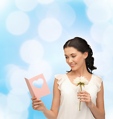 Image showing young woman holding flower and postcard