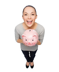 Image showing laughing woman with piggy bank
