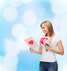 Image showing smiling girl with postcard and bouquet of flowers