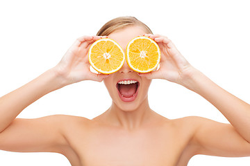 Image showing amazed young woman with orange slices