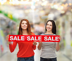 Image showing two smiling teenage girl with percent sign on box