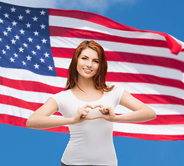 Image showing smiling girl showing heart with hands