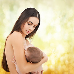 Image showing happy mother feeding her adorable baby