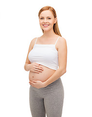 Image showing happy future mother touching her belly