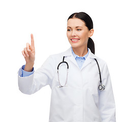 Image showing smiling female doctor pointing to something