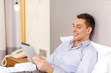 Image showing happy businesswoman with tablet pc in hotel room