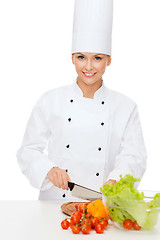 Image showing smiling female chef chopping vagetables