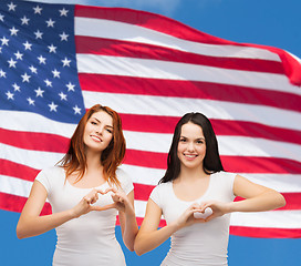 Image showing two smiling girls showing heart with hands