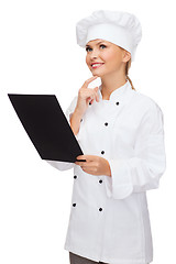 Image showing smiling female chef with black blank paper