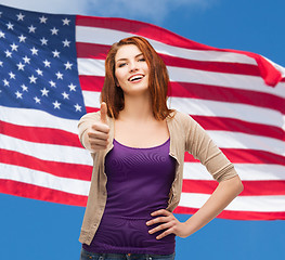 Image showing smiling girl in casual clothes showing thumbs up