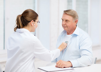 Image showing female doctor with old man listening to heart beat