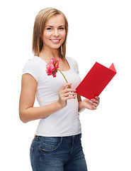 Image showing smiling girl with postcard and flower