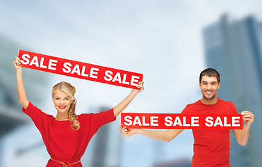 Image showing woman and man with red sale signs