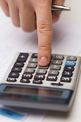 Image showing close up of businessman with papers and calculator