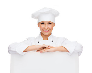 Image showing smiling female chef with white blank board